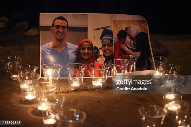 Candles are seen as a group of demonstrators gather in front of American Embassy in Amman to protest against the Chapel Hill shooting, in Amman,...