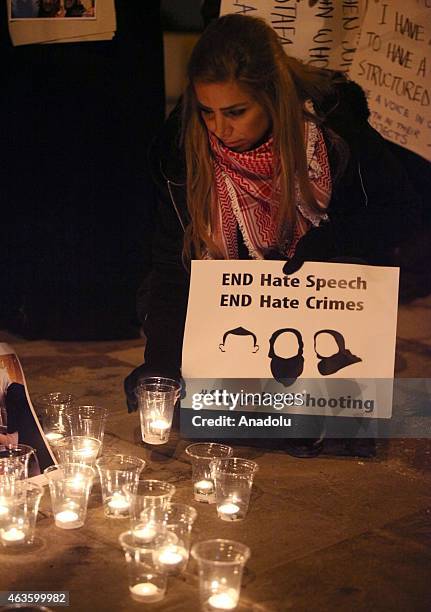 Candles are seen as a group of demonstrators gather in front of American Embassy in Amman to protest against the Chapel Hill shooting, in Amman,...