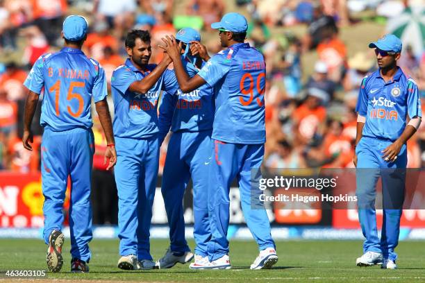 Mohammed Shami of India is congratulated by Ravichandran Ashwin after taking a catch off his own bowling to dismiss Nathan McCullum of New Zealand...