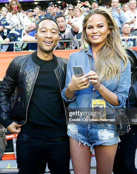 Musician John Legend and model Chrissy Teigen look on during Super Bowl XLIX between the Seattle Seahawks and the New England Patriots at University...