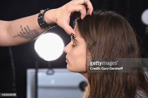Model is prepared backstage prior to the Reem Acra fashion show during Mercedes-Benz Fashion Week Fall 2015 at The Salon at Lincoln Center on...