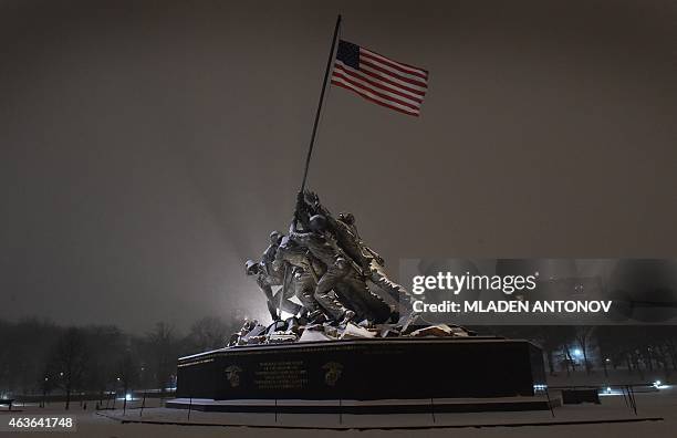 Snow falls on the Iwo Jima memorial in Washington DC on February 16, 2015. The eastern United States braced for an arctic onslaught, as forecasters...