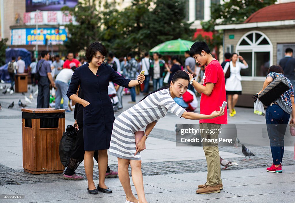 Tourists take selfies with all kinds of postures on a city...