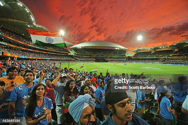 Indian fans in the crowd celebrate as a Pakistan wicket falls as the sun sets during the 2015 ICC Cricket World Cup match between India and Pakistan...
