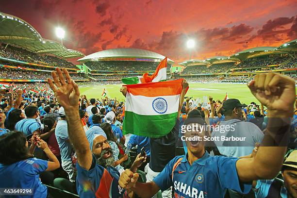 Indian fans in the crowd celebrate as a Pakistan wicket falls as the sun sets during the 2015 ICC Cricket World Cup match between India and Pakistan...