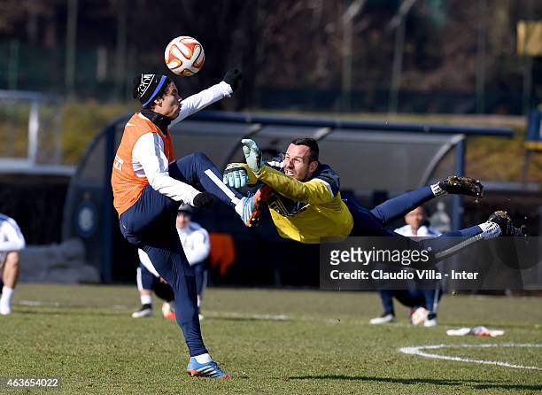 Hernanes and Samir Handanovic compete for the ball during a FC Internazionale training session at the club's training ground at Appiano Gentile on...
