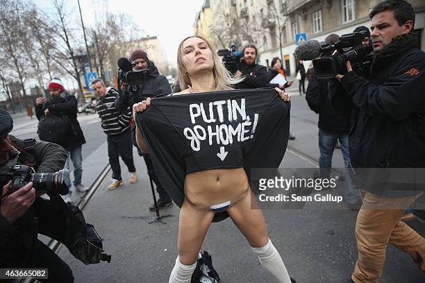 Nearly-naked Femen protester demonstrates against the scheduled visit of Russian President Vladimir Putin moments before she was detained by police...