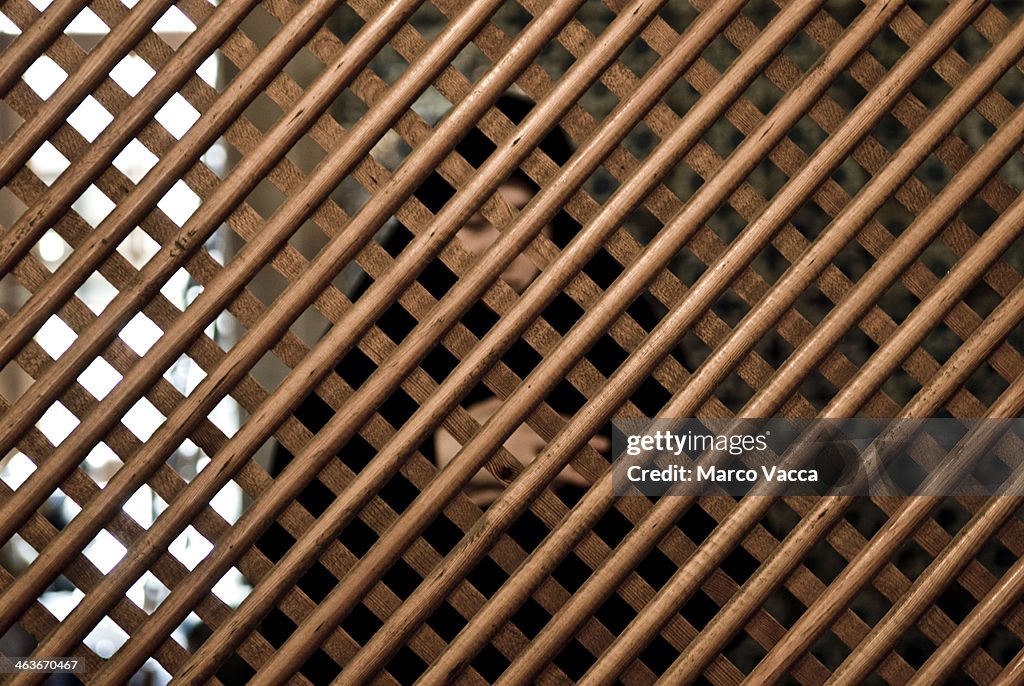 Muslim woman praying behind a fence