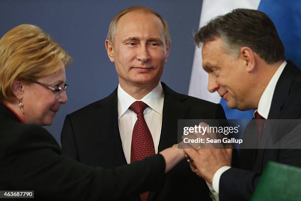 Russian President Vladimir Putin looks on as Hungarian Prime Minister Viktor Orban kisses the hand of a member of the Russian delegation during a...