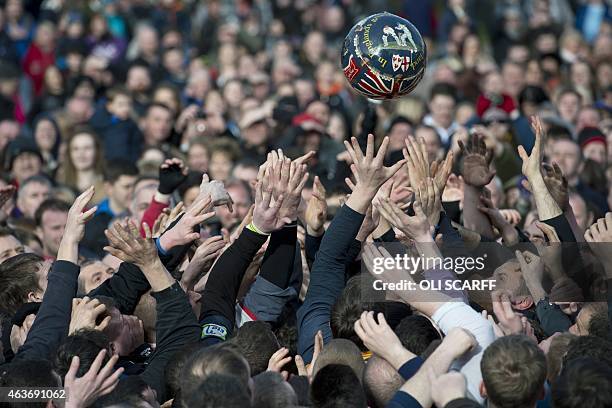 Opposing teams of the Up'ards and the Down'ards reach for the ball as they compete in the annual Royal Shrovetide Football Match in Ashbourne,...