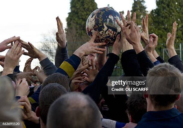 Opposing teams of the Up'ards and the Down'ards reach for the ball as they compete in the annual Royal Shrovetide Football Match in Ashbourne,...