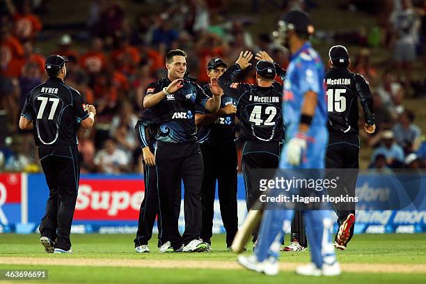 Mitchell McClenaghan of New Zealand celebrates with teammates Brendon McCullum after taking the wicket of MS Dhoni of India during the first One Day...