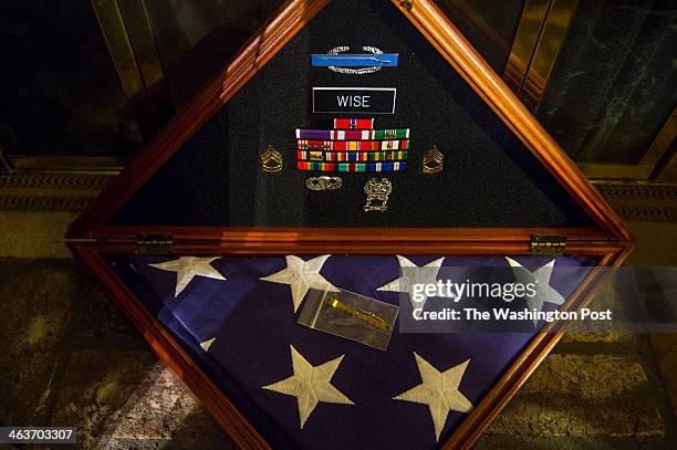 Service medals and a ceremonial flag belonging to Army Sgt. First Class, Special Forces Medic Benjamin B. Wise are displayed in a wooden box on the...