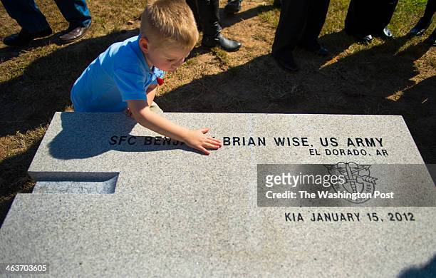 Luke Wise, 3 and widow Traci Wise, touches the granite bench bearing his father's name during a dedication ceremony at Southern Arkansas Community...