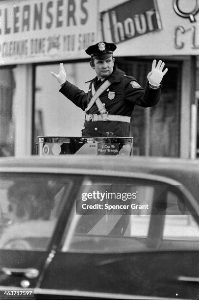 Policeman directs traffic, Somerville, Massachusetts, 1975.