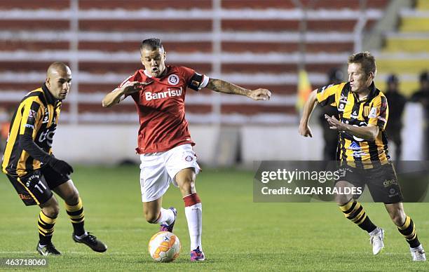 Footballer Andres D'Alessandro of Brazilian Internacional vies for the ball with Ernesto Cristaldo and Alejandro Chumacero of Bolivia's Strongest...