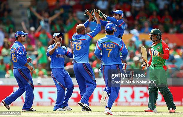 Merwais Ashraf of Afghanistan celebrates getting the wicket of Anamul Haque of Bangladesh with team mates during the 2015 ICC Cricket World Cup match...