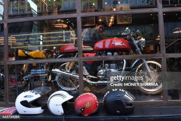 In this photograph taken on February 13 an Indian customer looks at a Royal Enfield Continental GT motorcycle on display at a showroom in New Delhi....