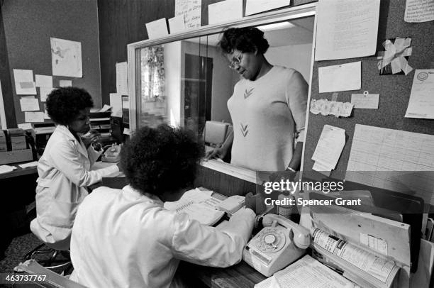 Patient approaches the counter, at an inner city medical clinic serving poor patients in Roxbury, Boston, Massachusetts, 1978.