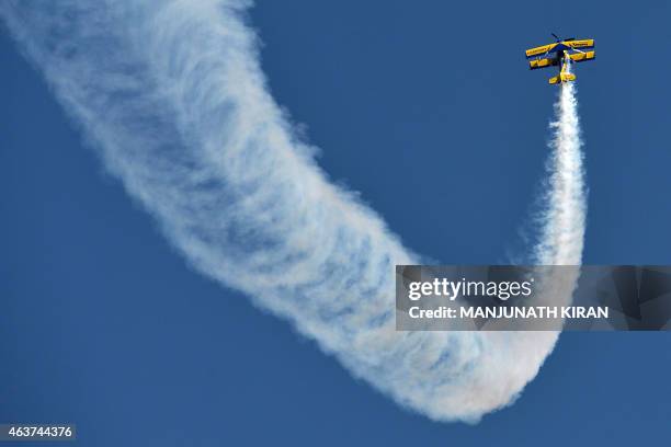 Britain's Breitling SkyWalkers Aerobatic Team members perform aerial stunts atop Boeing Stearman Biplane at Yelahanka Airforce Station in Bangalore...