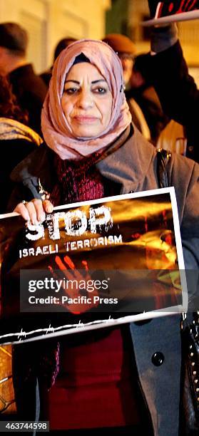 Woman holds up a poster during a vigil for the victims of the latest ISIS terror killings in the West Bank city of Beit Sahur. Following another...
