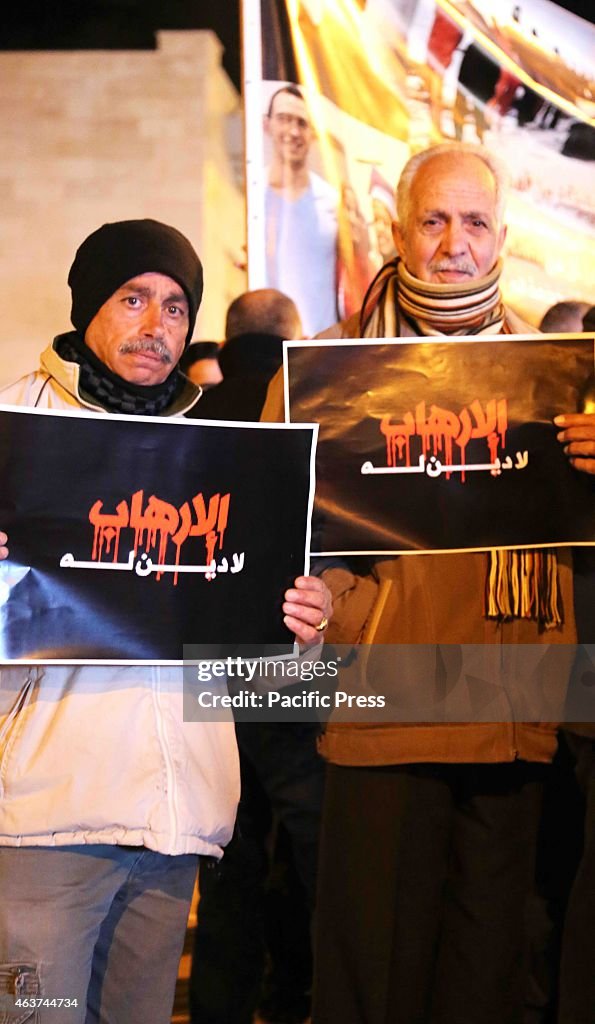 Two Palestinian men hold up posters during a vigil held in...