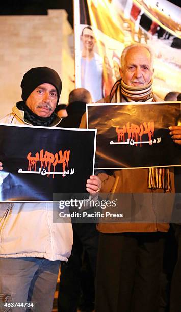 Two Palestinian men hold up posters during a vigil held in the West Bank city of Beit Sahur. Following another video released by ISIS on Sunday which...
