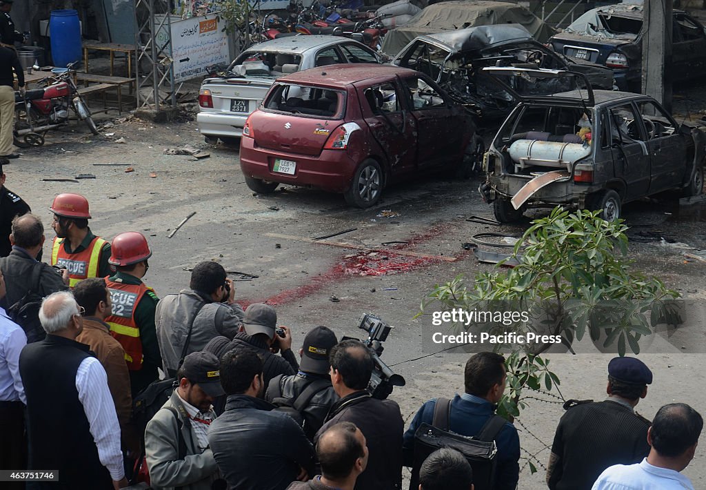 Pakistani security officials and residents gather at the...