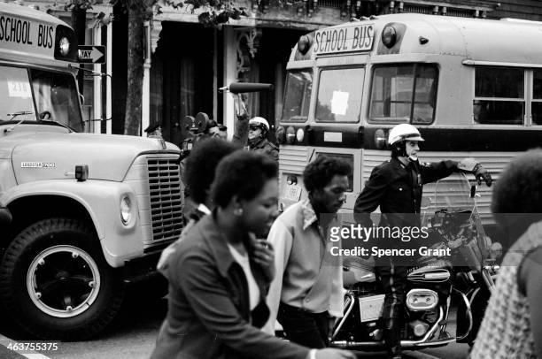 Bused black schoolchildren arrive with police escort at South Boston High School during court-ordered desegregation crisis, South Boston,...