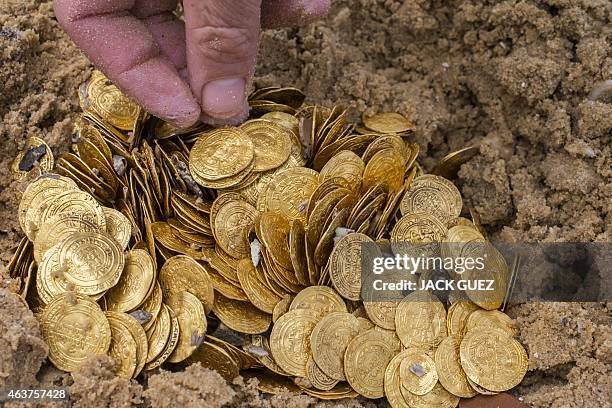 Gold coins which were recently found on the seabed off Israel's Mediterranean coast, are seen displayed in sand in the Israeli town of Caesarea, on...