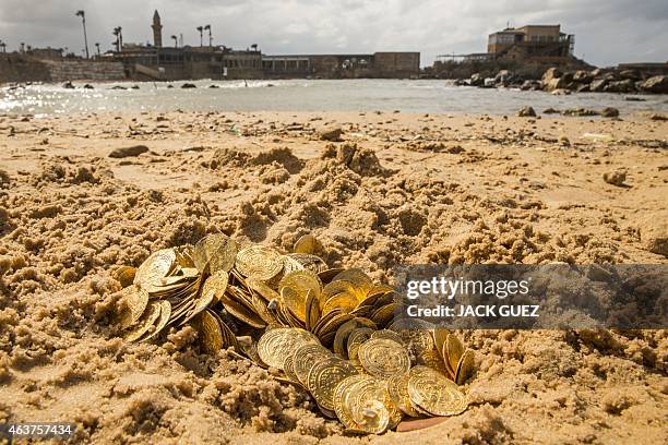 Gold coins which were recently found on the seabed off Israel's Mediterranean coast, are seen displayed in sand in the Israeli town of Caesarea, on...