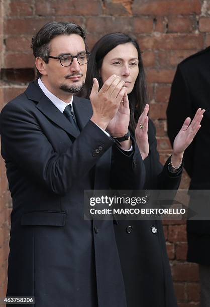 The son of Michele Ferrero, Giovanni Ferrero flanked by his wife Paola applaud the coffin of his father during the funeral on February 18, 2015 in...