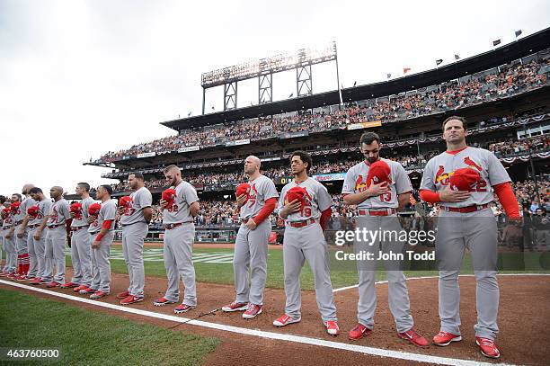 Members of the St. Louis Cardinals are seen on the base path during the singing of the National Anthem before during Game 3 of the NLCS against the...