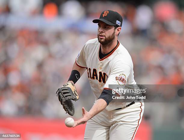 Brandon Belt of the San Francisco Giants flips the ball to first base during Game 3 of the NLCS against the St. Louis Cardinals at AT&T Park on...