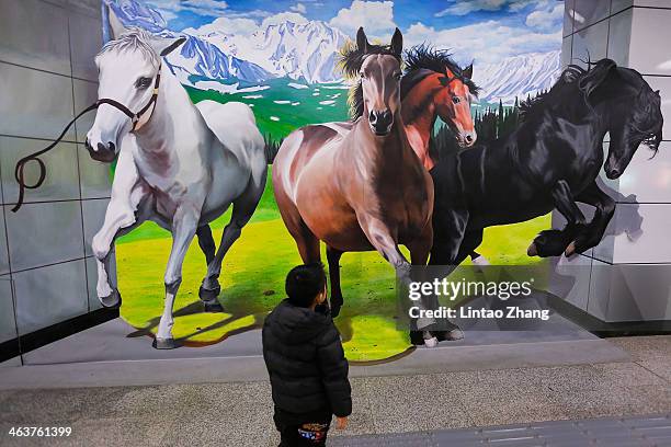 Child watching 3D horse painting is on display at a subway station on January 19, 2014 in Beijing, China. The Chinese Lunar New Year of horse also...