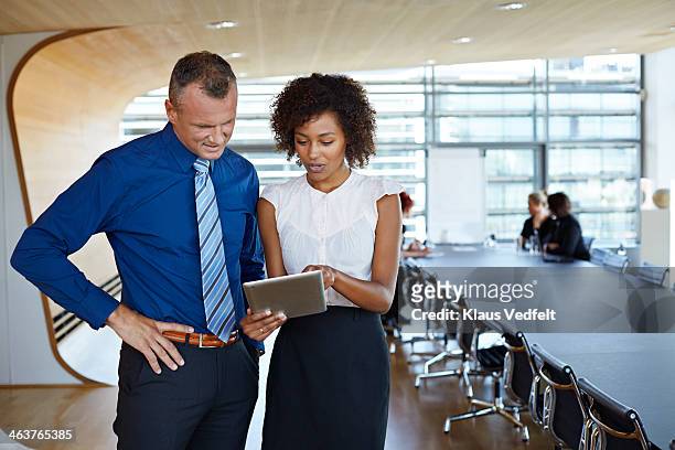 businesswoman showing her boss results on tablet - formal businesswear stock pictures, royalty-free photos & images