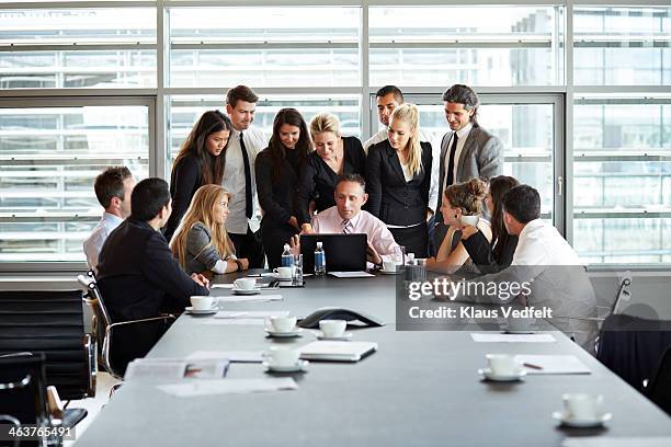 big business people group squeezing around laptop - surrounding ストックフォトと画像