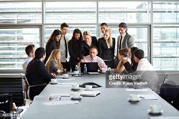 big business people group squeezing around laptop - omgeven stockfoto's en -beelden