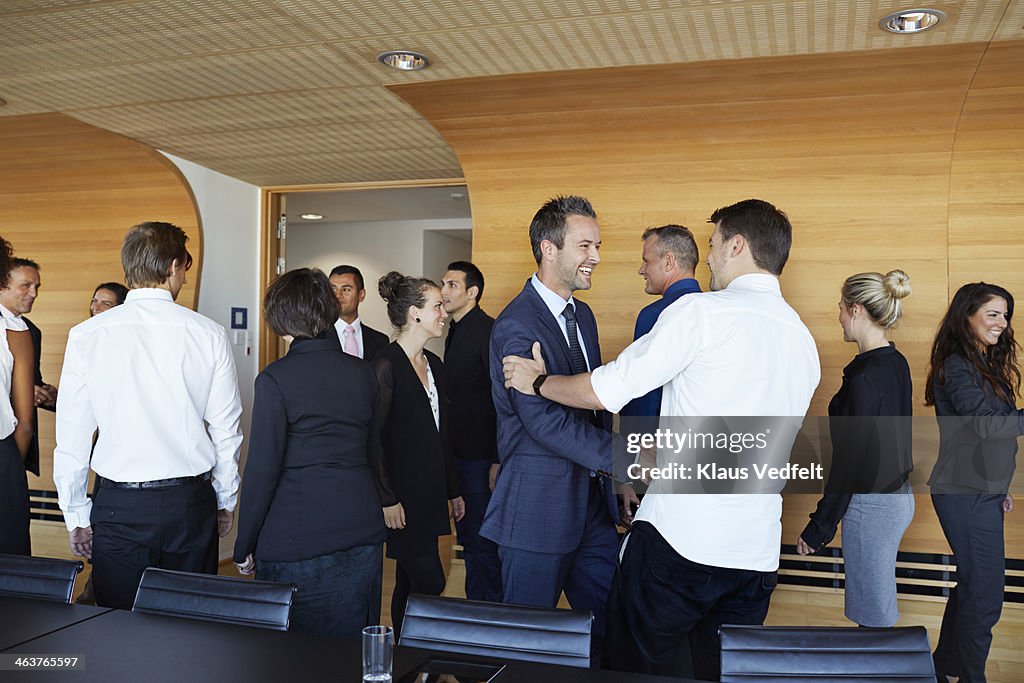 Business people making handshake in meeting room