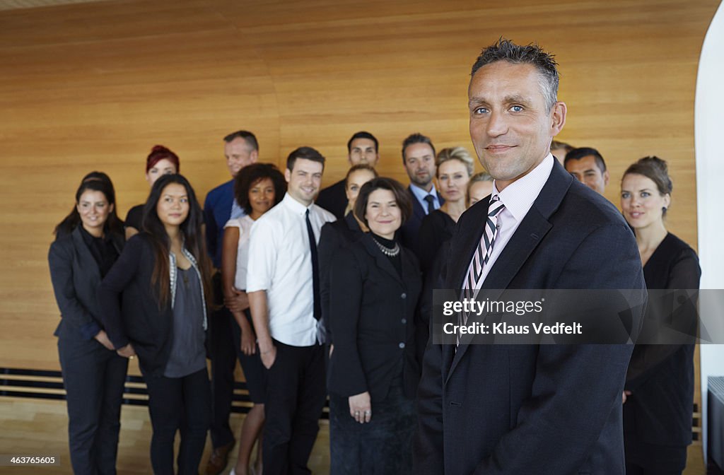 Portrait of businessman, coworkers in back