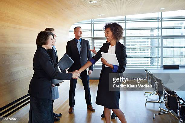 business people shaking hands at meeting - meeting candid office suit stockfoto's en -beelden