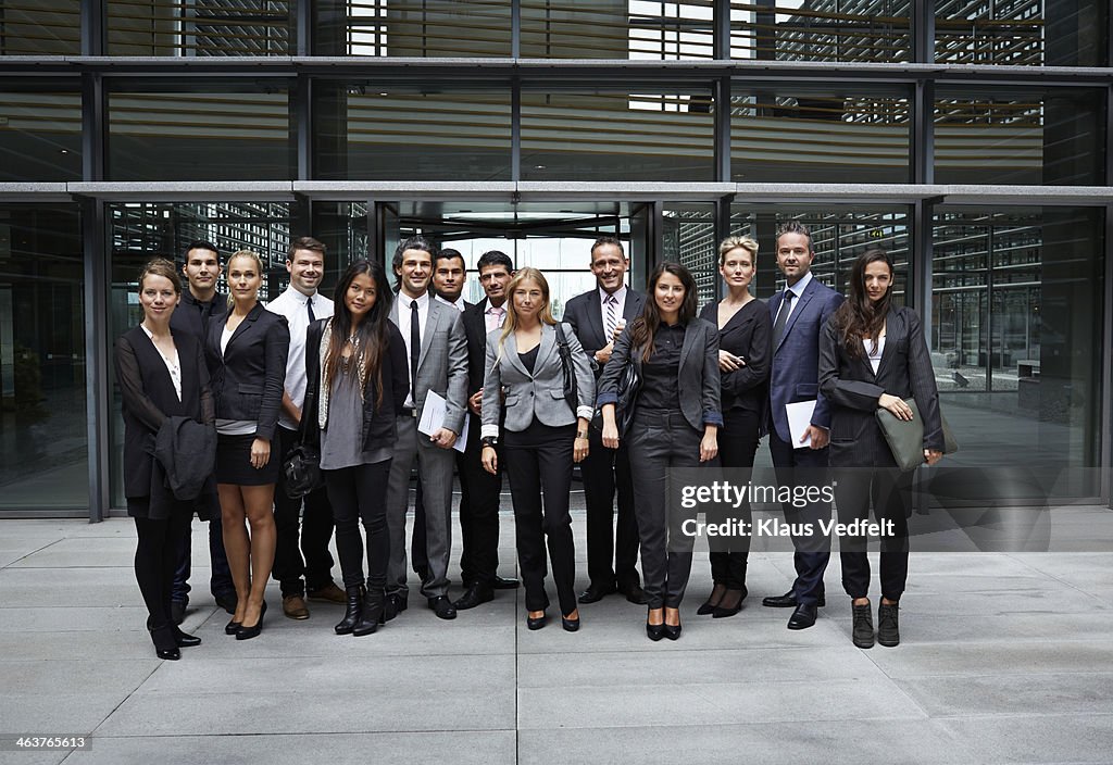 Group shot of business people outside corporation