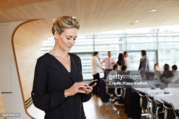 businesswoman using smartphone in conference room - bem vestido imagens e fotografias de stock