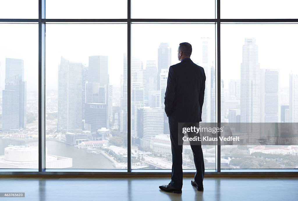 Businessman looking out of window watching skyline