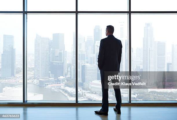 businessman looking out of window watching skyline - corporate skyline stock pictures, royalty-free photos & images