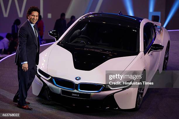 Former cricket player Sachin Tendulkar poses next to the BMW i8, a hybrid sports car, during its launch on February 18, 2015 in Mumbai, India. At Rs...