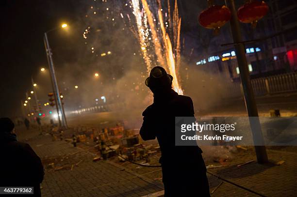 February 19: A Chinese man watches as firecrackers he lit explode during celebrations of the Lunar New early on February 19, 2015 in Beijing,...