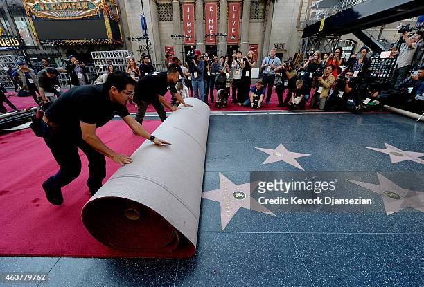 Workers Rodolfo Morales and Ernest Jauregui roll out the ceremonial red carpet over the Hollywood Walk of Fame stars on Hollywood Boulevard in...