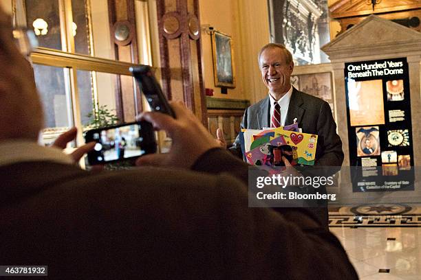 Bruce Rauner, governor of Illinois, right, stands for a photograph while returning to his office at the Illinois State Capitol after delivering a...