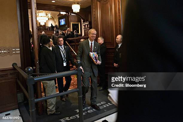 Bruce Rauner, governor of Illinois, center, leaves the House Chamber at the State Capitol building after delivering a budget address in Springfield,...
